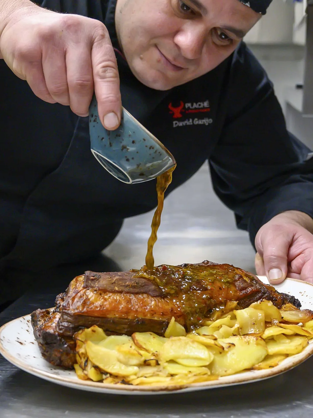 Salseando un costillar recién asado en la cocina de Plaché