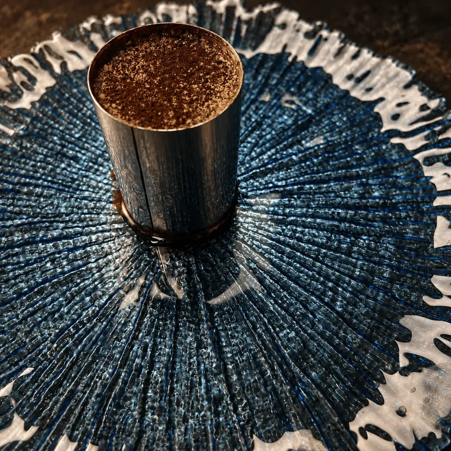 Tiramisú servido en aro, espolvoreado de cacao